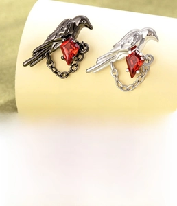 Detailed view of crow chain earring with titanium steel and red zircon stone