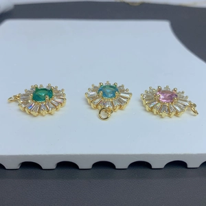 Detailed view of sunburst flower pendants with emerald, aquamarine, and pink zircon stones
