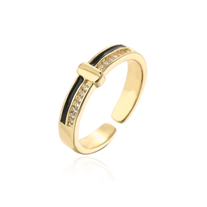 Macro detail of gold-plated ring featuring black enamel stripes and cubic zirconia stones