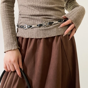 Detail of vintage silver metal discs and black leather connections on a stylish waist belt