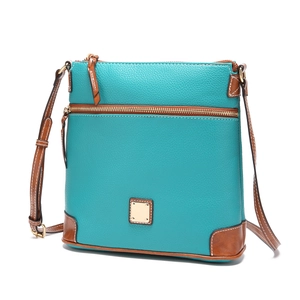 Detail of blue lychee leather crossbody bag with brown leather trim and golden zipper