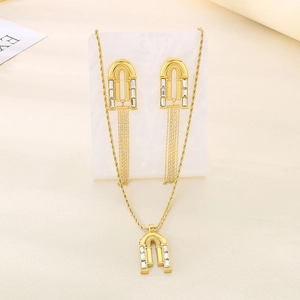 Detailed view of gold arch pendant and tassel earrings set with clear crystals
