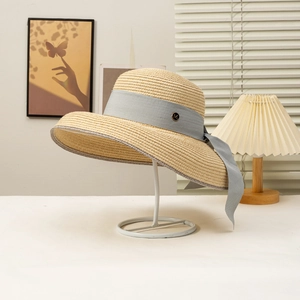 Elegant wide-brim straw sun hat with grey ribbon and gold M-logo for beach holidays