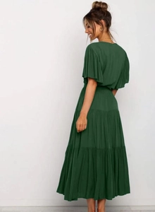 Detalle de un vestido bohemio verde oscuro con volantes y mangas cortas elásticas