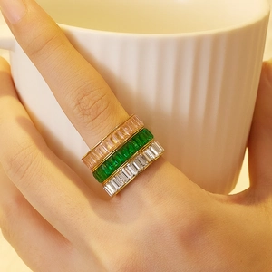 Three stacked gold-plated stainless steel rings with pink, green and white baguette-cut zircon