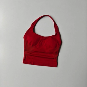 Close-up of red halter sports bra showing seamless knit texture and mesh detailing