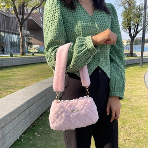 Pink quilted plush faux fur shoulder bag with gold chain shown in a casual outdoor setting
