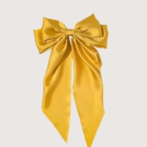 Elegant large yellow satin bow hair clip with a silky glossy finish for women
