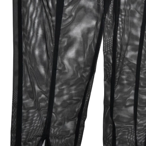 Détail de legging en tulle noir transparent avec patchwork de rayures verticales texturées
