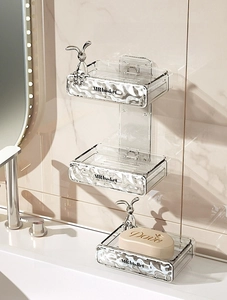 Detail of wall-mounted double soap dish with silver bunny accent and wavy texture