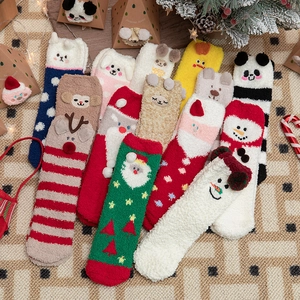 Plush Christmas socks featuring reindeer and Santa Claus designs in warm coral fleece