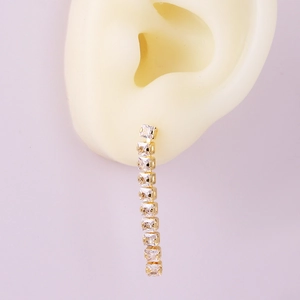 Close-up of golden V-shape earrings with linear square cubic zirconia on model