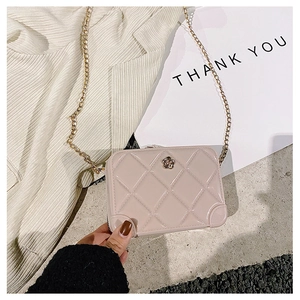 Detailed view of beige quilted jelly bag with gold flower clasp and chain strap