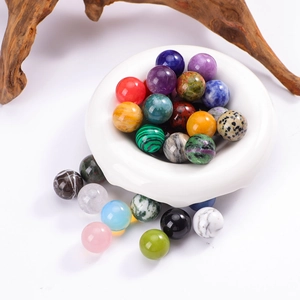 Polished 16mm natural gemstone spheres in various colors displayed in a white bowl