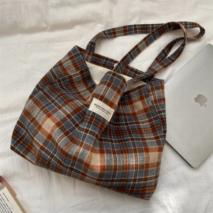 Macro detail of classic plaid canvas tote with a woven brand label and sturdy handles