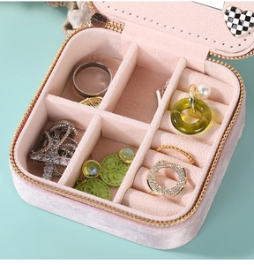 Pink velvet jewelry box interior detail showing multi-slot ring and earring storage