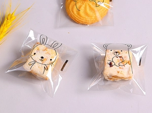 Close-up of cute cartoon rabbit and bear patterns on transparent cookie packaging bags