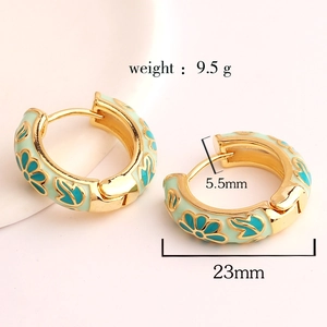 Detail view of blue enamel flower hoop earrings with size specs 23mm diameter and 9.5g weight