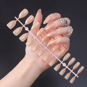 Polished almond and square nude pink press-on nails shown on hand with silver ring
