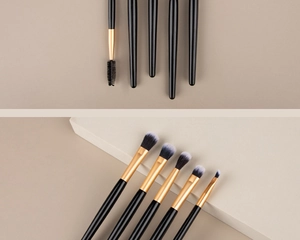 Close-up of dual-ended eye makeup brushes with gold ferrule and gradient soft bristles