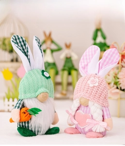 Detail of plush Easter gnomes with knitted hats and carrot decor in a spring scene
