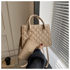 Detailed macro of beige quilted handbag featuring matching coin purse and smooth leather texture