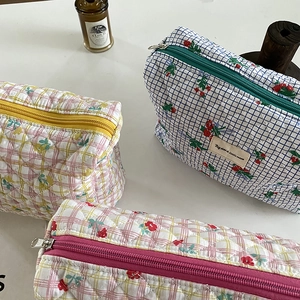 Detailed view of quilted cotton cosmetic bags in cherry and floral patterns