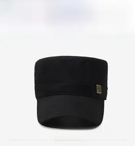 Detail of a black flat top military cap with a vintage metal plate and precise stitching
