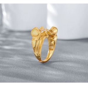 Macro shot of gold pleated ruffle ring with sparkling white zircon stones and open band