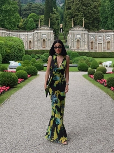 Détail d'une robe longue fluide à imprimé abstrait dans un jardin