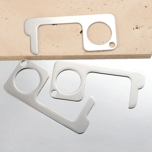 Three silver stainless steel non-contact door opener tools on a stone and mirror surface