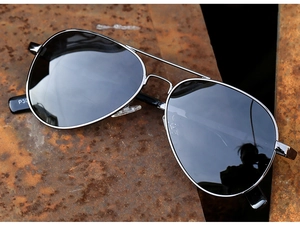 Detail view of polarized aviator sunglasses with gunmetal frame on industrial background