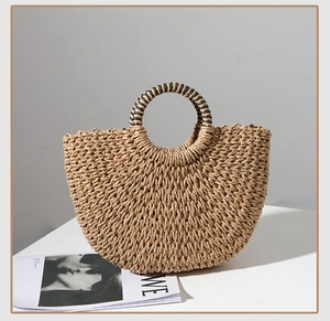 Detail of hand-woven straw shell bag featuring black and yellow rope handle textures