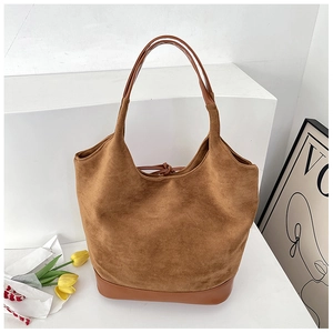 Detail of suede texture and leather stitching on the brown minimalist shoulder tote bag
