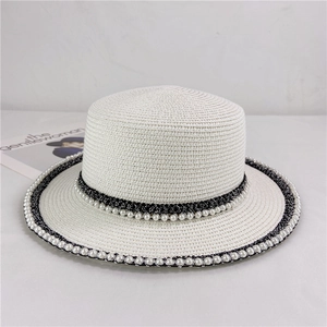 Detailed view of the fine straw weaving, elegant black lace, and pearls on the hat