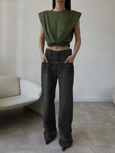 Detail view of wide-leg dark grey denim pants paired with a dark green sleeveless crop top