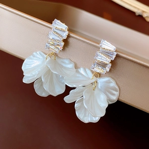 Elegante vergoldete Blumenohrringe mit schimmernden Harzblättern und Zirkonsteinen
