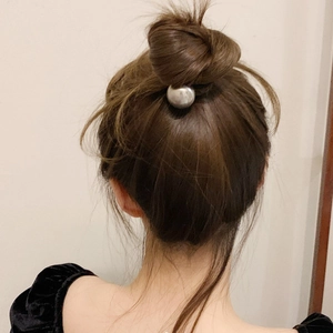 Minimalist silver metallic sphere hair tie styled on a sleek bun for a modern look