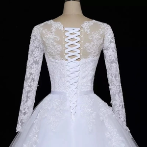 Elegant white long sleeve bridal gown with detailed lace and lace-up back design