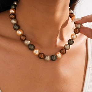 Gros plan sur un collier de perles fantaisie multicolores aux tons champagne et gris