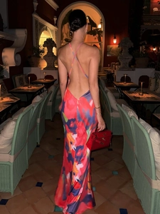 Back view of a backless floral maxi dress with slim lace straps in a night setting