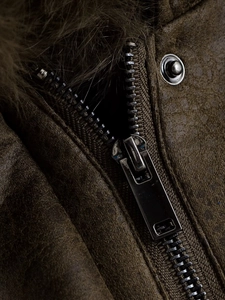 Macro detail of high-quality metal zipper and gray faux fur collar on brown suede jacket