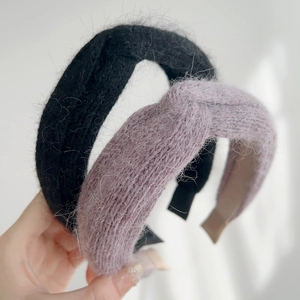 Detail showing plush knitted cross-knot headbands in black and grey-purple mink-like texture