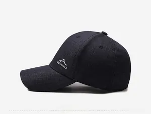 Detail view of the embroidered mountain logo and white text on dark baseball cap side