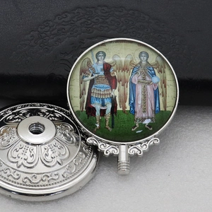 Detailed view of silver religious pendants featuring ornate patterns and angel iconography
