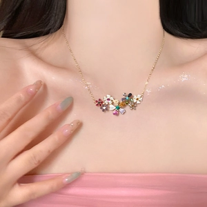 Collier en acier doré avec pendentif fleur en cristal coloré porté par un mannequin