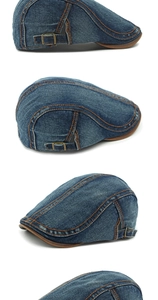Detail of washed blue denim beret with orange contrast stitching and metal buckle