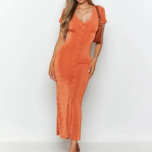 Macro detail of the orange V-neck maxi dress featuring sleek short sleeves and front buttons