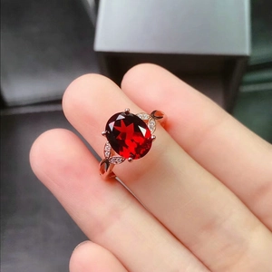 Elegant rose gold open ring with oval red garnet stone and leaf-shaped diamond accents