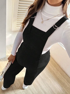Close-up of black corduroy maternity overalls with metal rings and soft ribbed texture